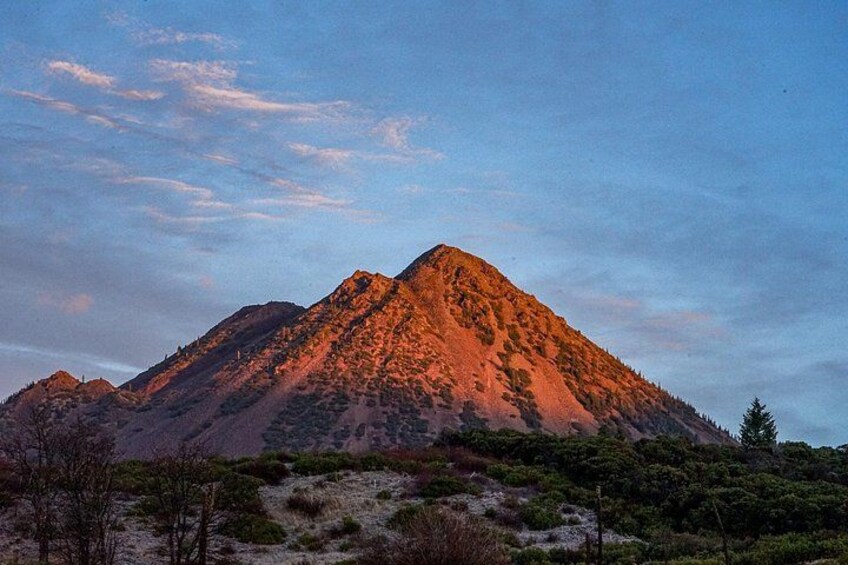 A mountain range with a prominent peak during sunset. 4