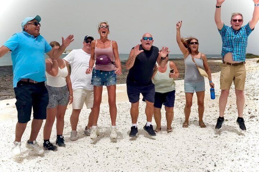 A group of people on a sandy beach with the ocean in the background. 2
