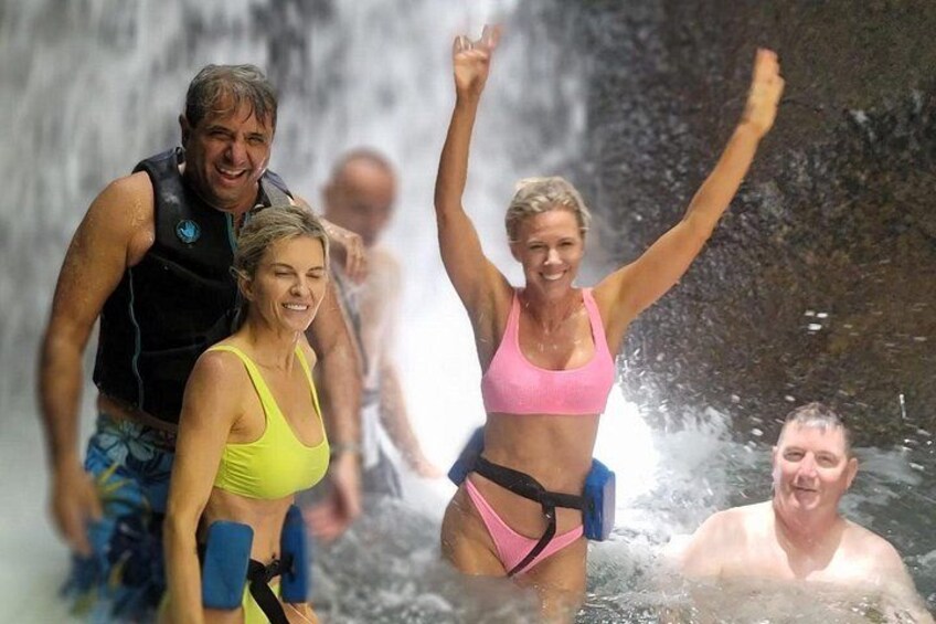 People in water with a waterfall in the background. 3
