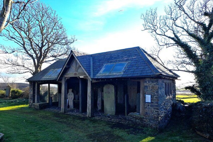 A stone building with a sloped roof and a small porch. 3