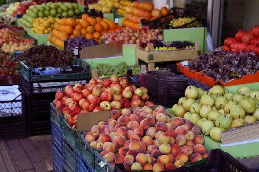 A fruit market with various fruits like apples, oranges, and pears displayed in crates. 1