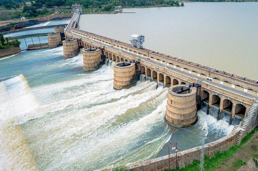 A large dam with multiple spillways and water flowing over them. 2