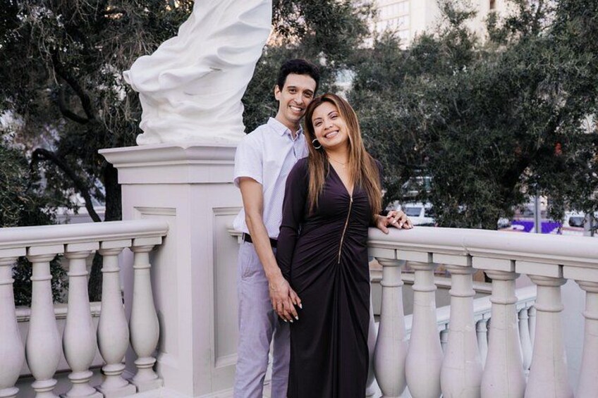 Una pareja de pie sobre una barandilla blanca con una estatua blanca al fondo. 5