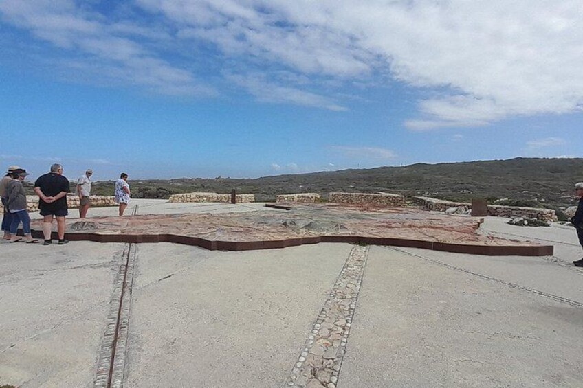 A group of people standing on a concrete platform with a view of the landscape. 4