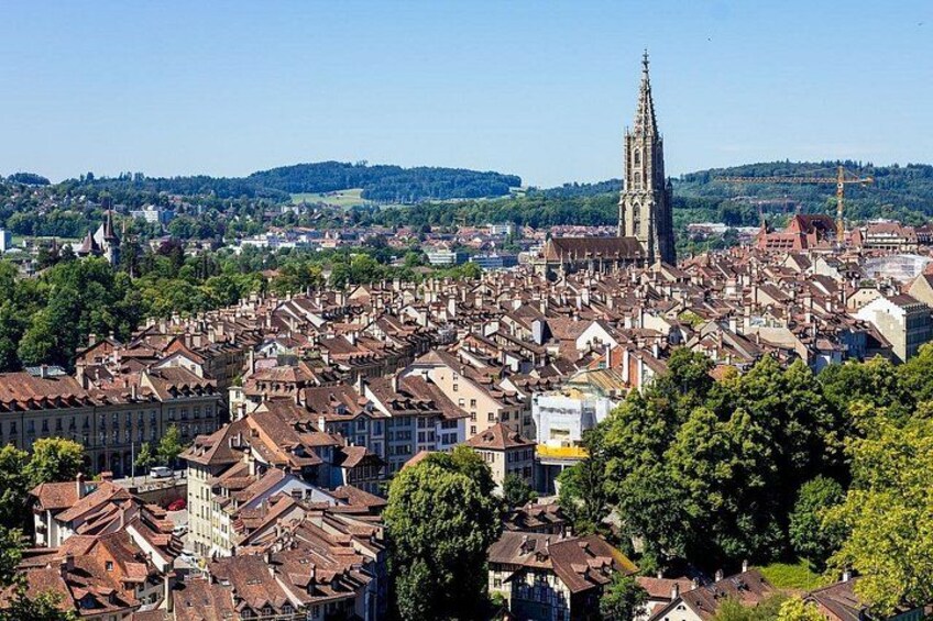 A cityscape with a prominent cathedral, dense residential buildings, and a hilly landscape in the background. 5