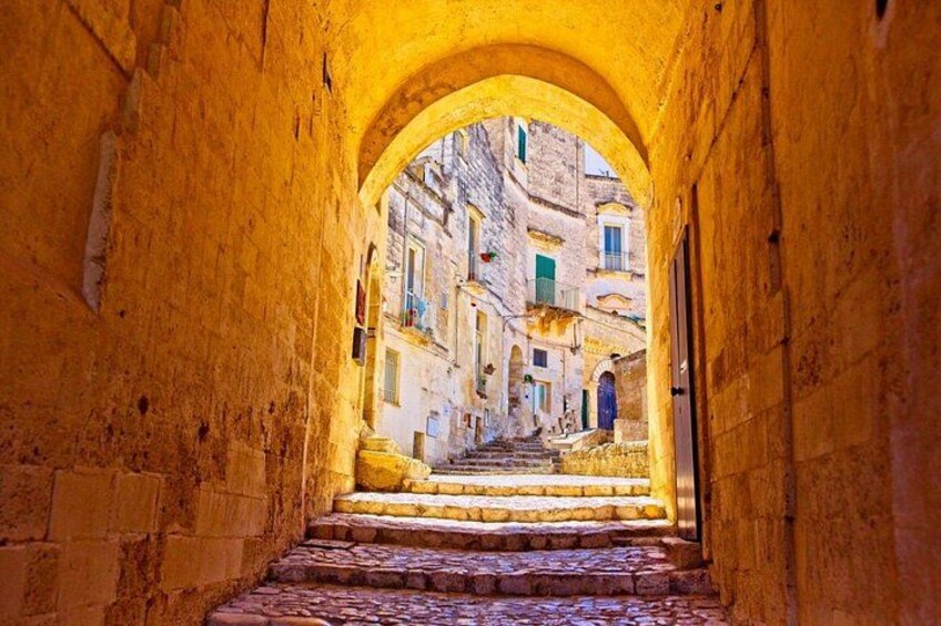 A stone staircase leading through a narrow archway in a historic town. 4