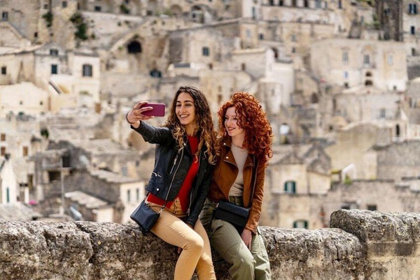 Two people taking a selfie with a historic cityscape in the background. 2