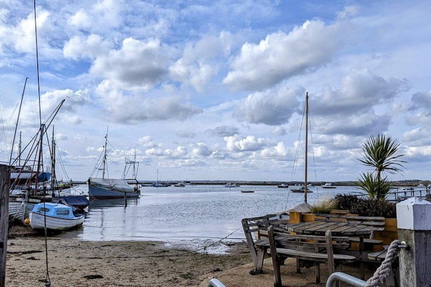 Een jachthaven met boten, een zandstrand en een bewolkte lucht. 5