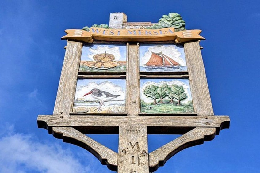 Een houten bord met vier vakken waarop een vogel, een zeilboot, een boom en een landschap staan afgebeeld. 4