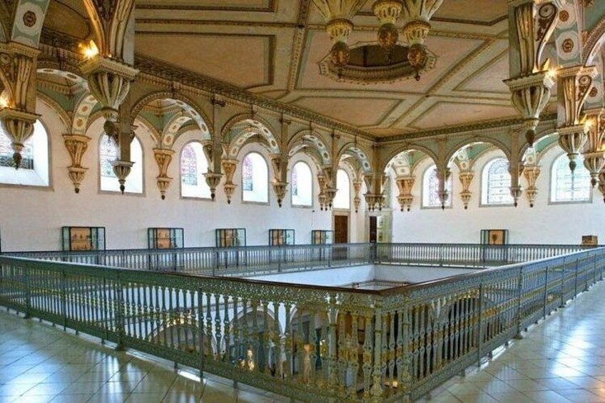 Un hall somptueux, doté d’arches au niveau des fenêtres, d’un espace central ouvert et d’une balustrade décorative. 3