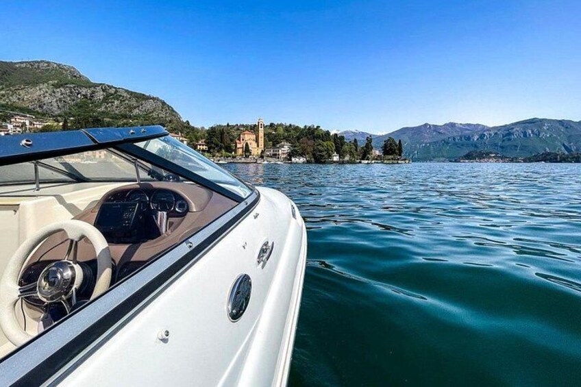 A boat on calm water with a mountainous landscape and a building in the background. 4