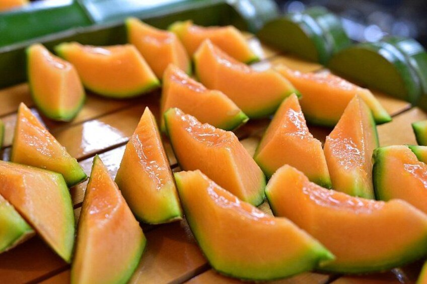 Sliced cantaloupe arranged on a wooden surface. 2