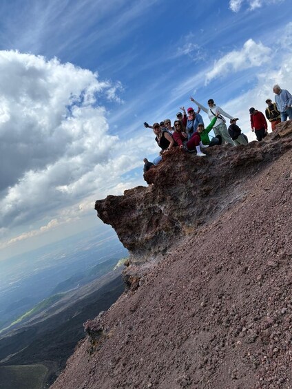 A group of people on a rocky outcrop with a view of the landscape below. 1
