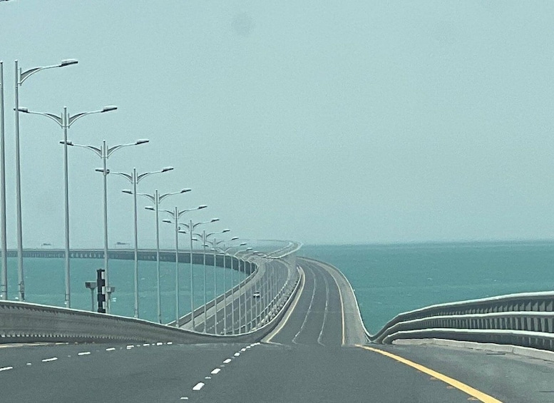 A coastal highway with streetlights and a clear view of the ocean. 4