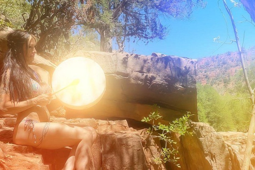 A person sitting on a rock with a glowing object in hand. 5
