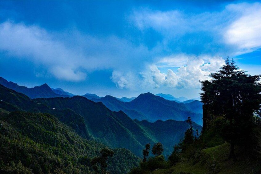 A mountainous landscape with dense forests and a clear sky. 1