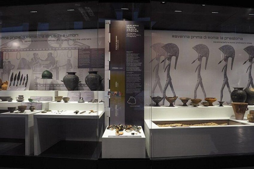 An exhibition of ancient Roman artifacts, including pottery and sculptures, displayed in glass cases. 4