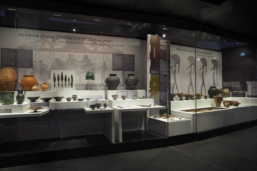 An indoor museum exhibit with ancient pottery and sculptures. 5