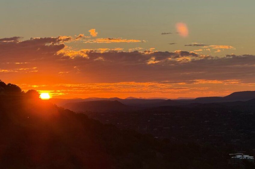 A sunset over a mountainous landscape with a city in the foreground. 3