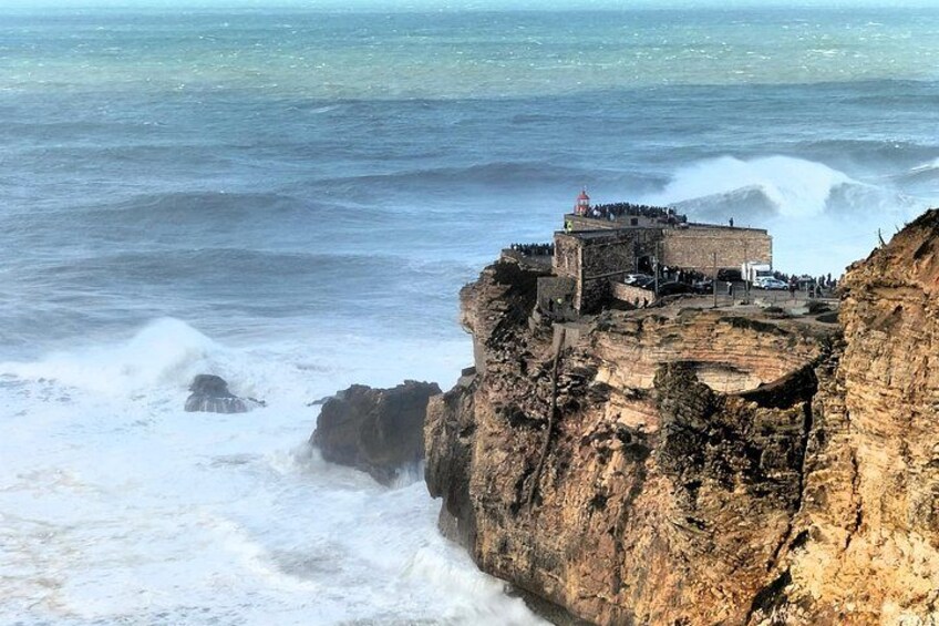 A coastal cliff with a lighthouse and a fortified structure. 3