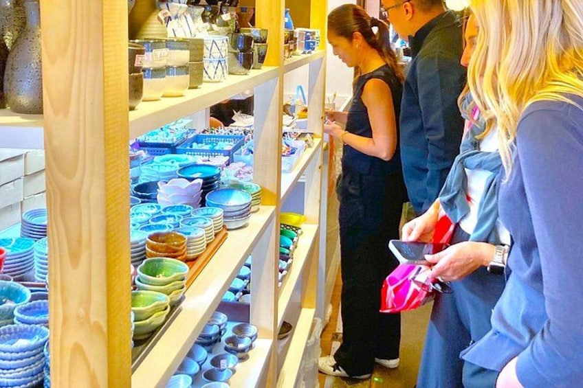 A store with shelves of colorful bowls and plates. 2