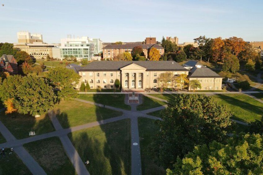 A campus with a central building, green lawns, and surrounding trees. 2