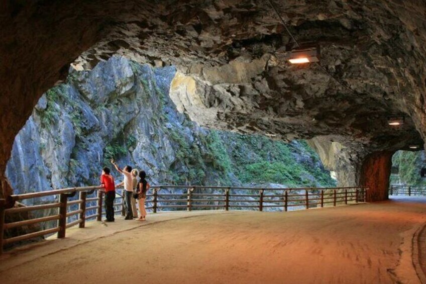 A cave interior with rocky walls and a wooden railing. 1