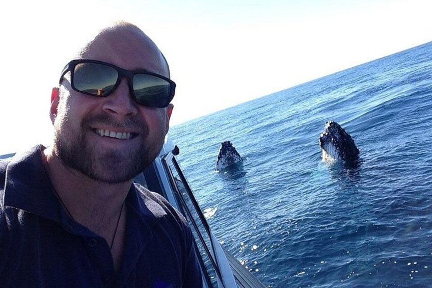 A person on a boat with two large rock formations in the ocean. 2