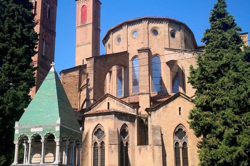 En historisk kyrka med ett framträdande klocktorn och en byggnad med grön takbeklädnad. 4