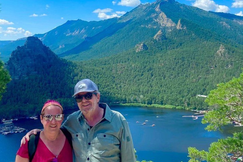 Una pareja de pie junto a un lago con montañas al fondo. 3
