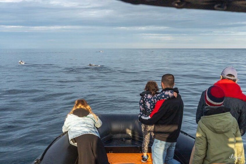 Un groupe de personnes se trouve sur un bateau, avec une mer calme et un ciel dégagé en arrière-plan. 4