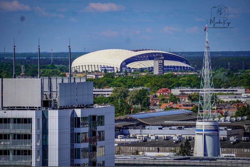 A stadium, a tall communication tower, and modern buildings. 5
