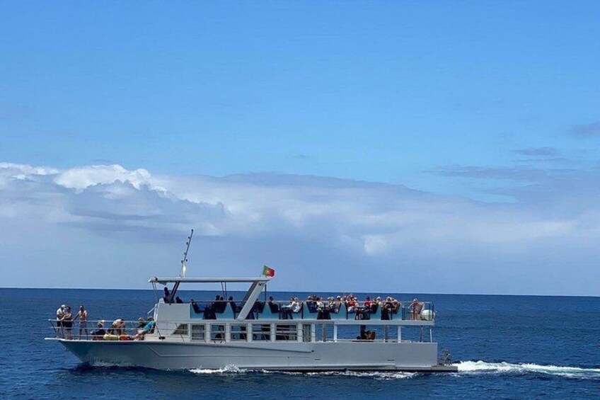 Un bateau transportant des passagers sur une mer calme, sous un ciel dégagé. 2