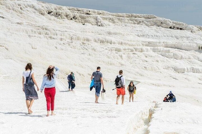 People walking on a white, terraced landscape. 5
