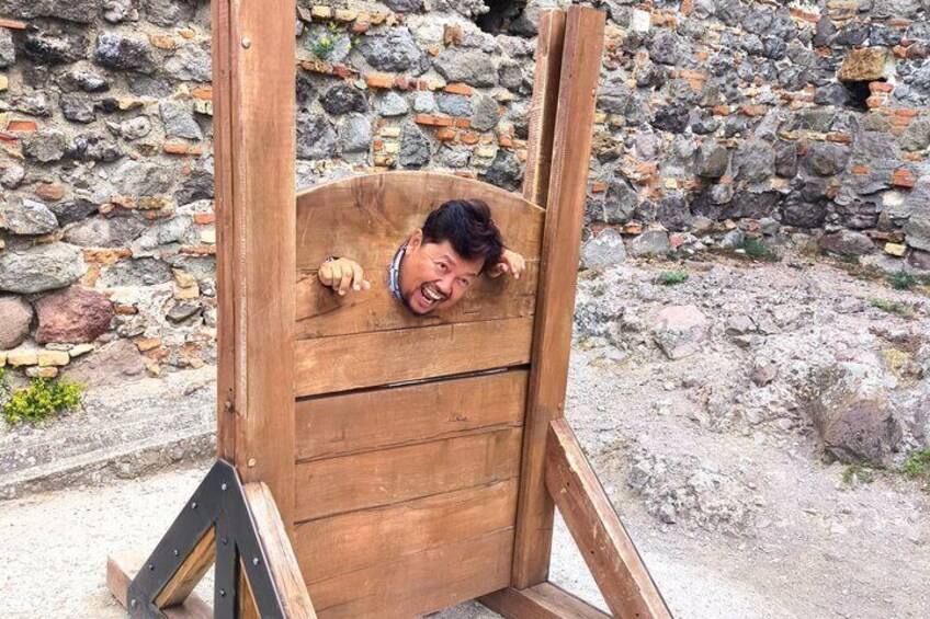 Una struttura in legno con una persona che spia da dietro. 1