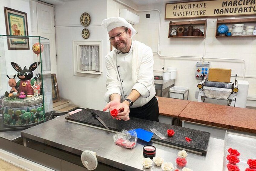 A chef in a kitchen with a cutting board, a knife, and various food items. 3