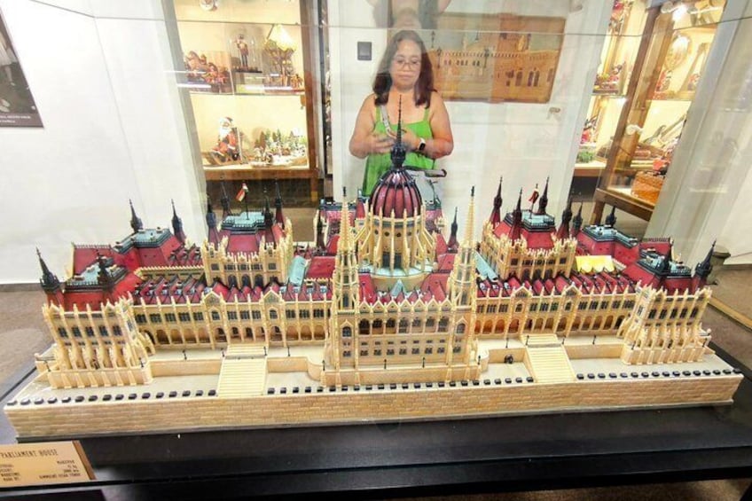 A detailed model of a grand building with multiple spires and a central dome, displayed on a platform. 2
