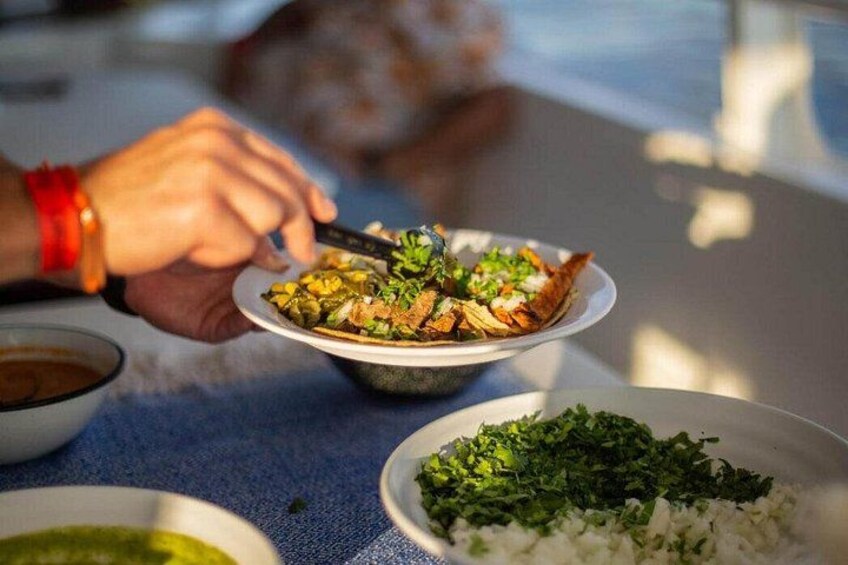 A person eating a meal with a bowl of rice and a plate of food. 3