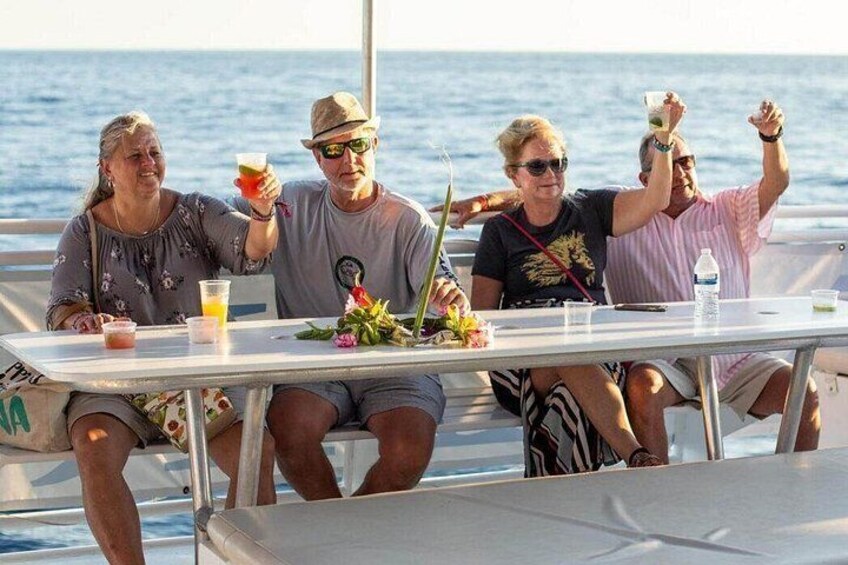 Un grupo de personas en un barco, con bebidas y un ordenador portátil. 5