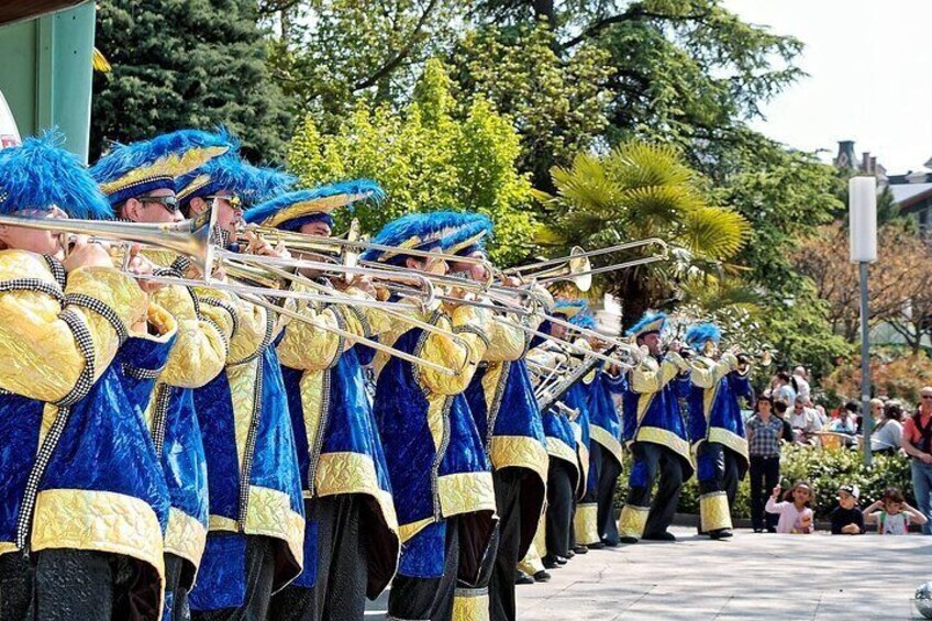 A brass band in blue and gold uniforms marching in formation. 3