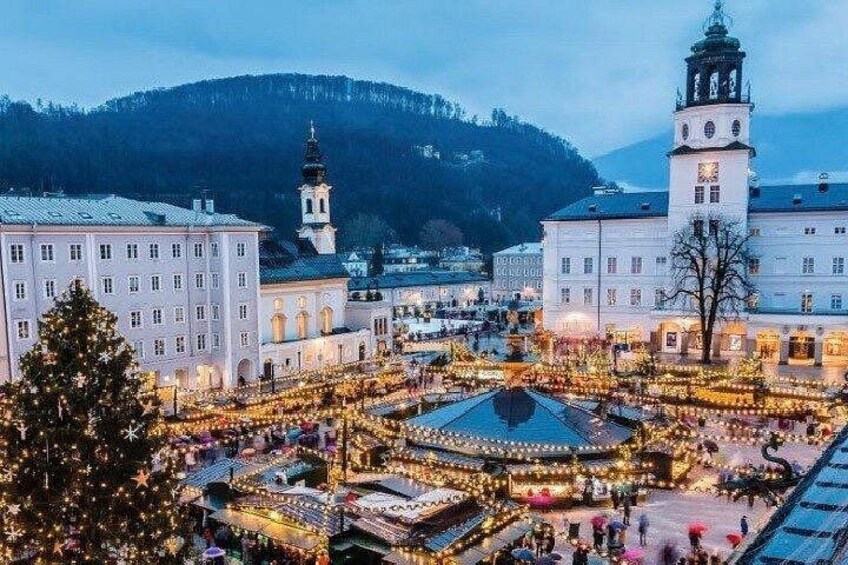 Una plaza festiva con decoraciones iluminadas, edificios históricos y una imponente torre del reloj. 2