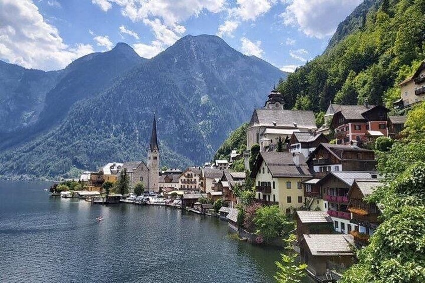 Un pueblo a orillas de un lago, con una iglesia, casas coloridas y montañas al fondo. 4