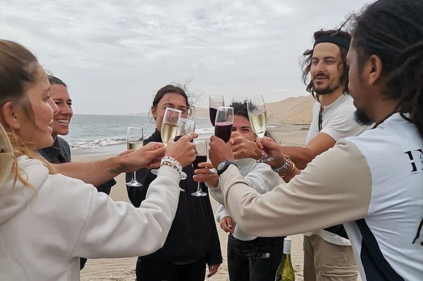 Un grupo de personas brindando con copas de champán en la playa. 3