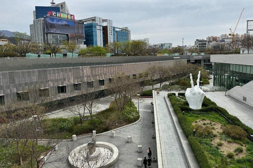 A modern building complex with a large sculpture in the foreground. 3