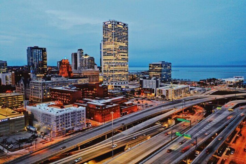 A cityscape with a prominent tall building, multiple highways, and a body of water in the background. 3