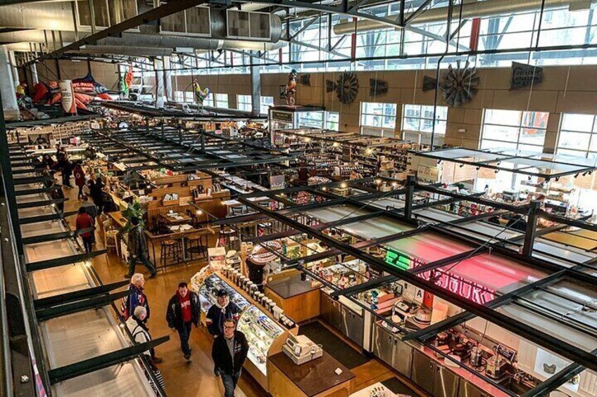 A large indoor market with multiple levels of stalls and shoppers. 5