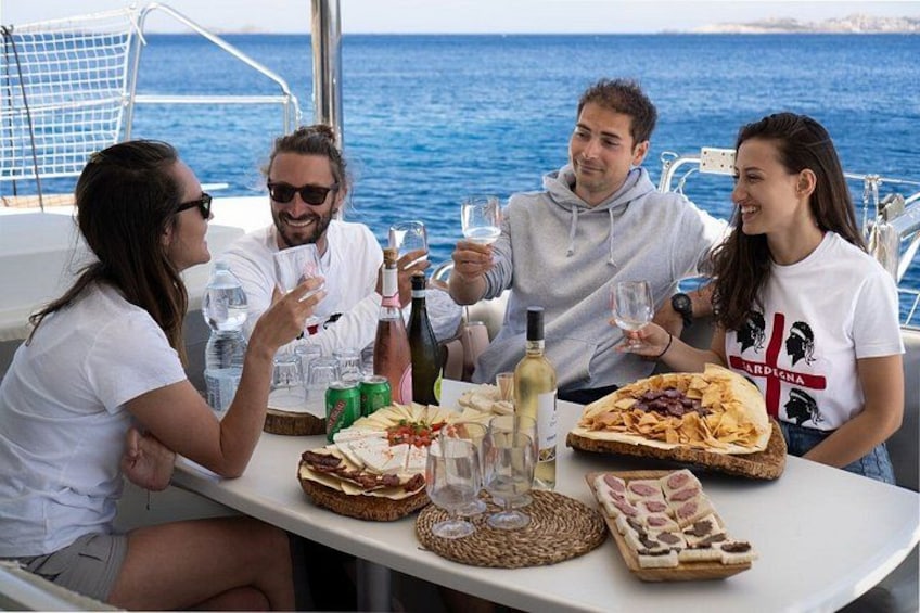 A group of people on a boat with food and drinks. 4
