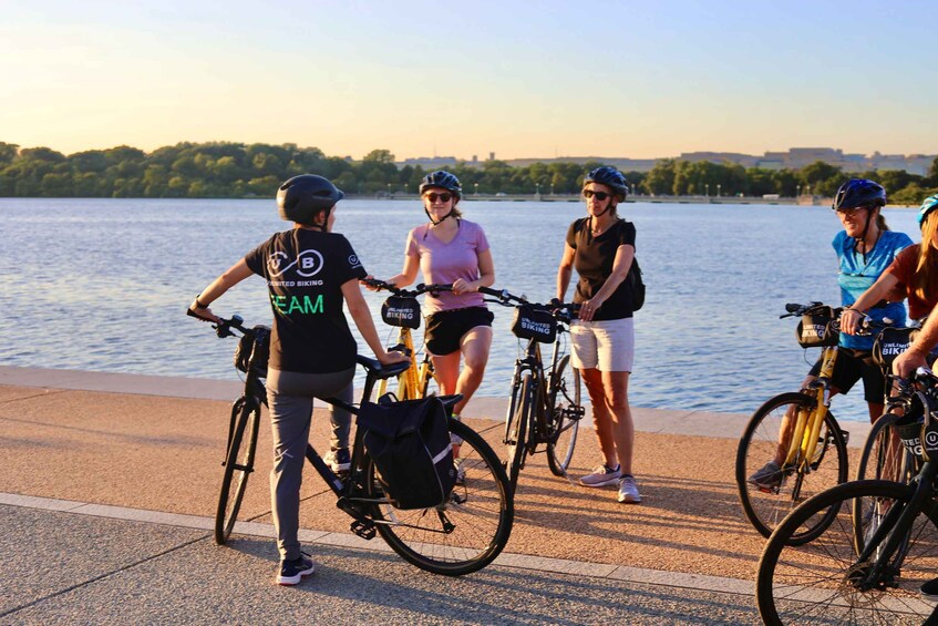 A group of people on bicycles by a waterfront. 4