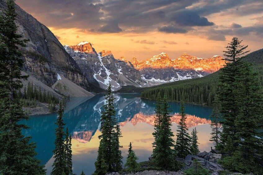 A mountain lake with reflections, surrounded by coniferous trees and snow-capped peaks. 1