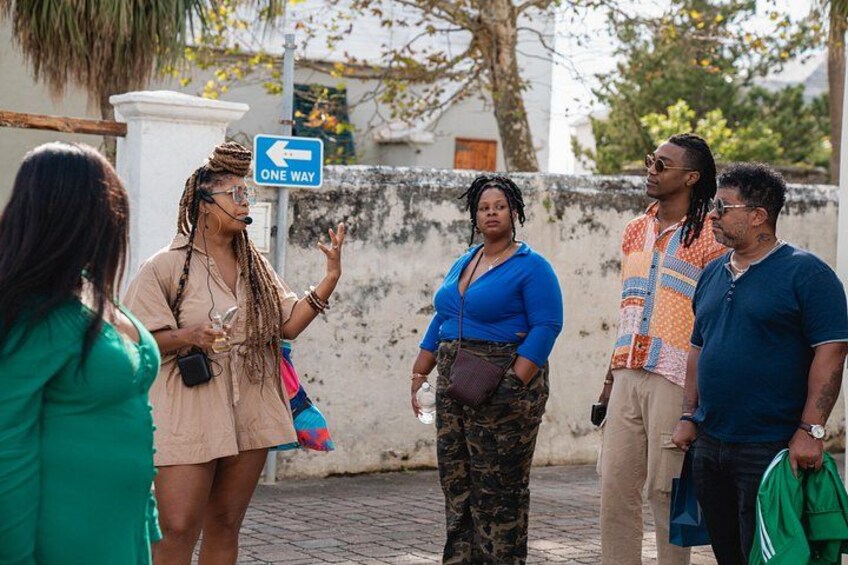 A group of people standing on a street with a one-way sign. 2
